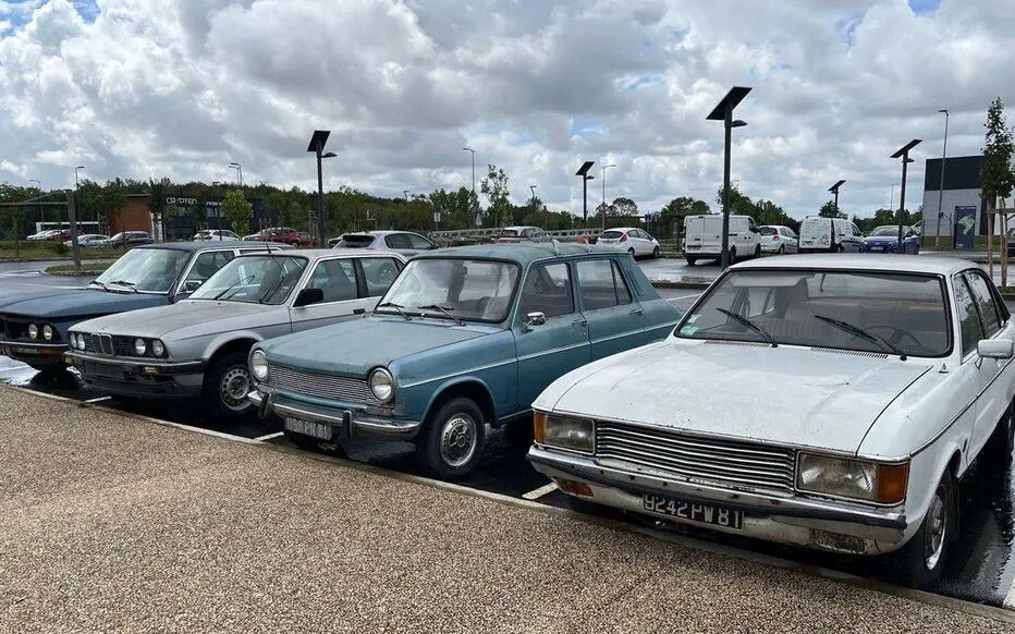 Découverte surprenante : une collection de voitures anciennes garée sur une aire de covoiturage